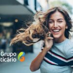 uma jovem mulher sorridente falando ao telefone sobre uma vaga home office no Grupo Boticário