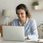 Profissional sorridente trabalhando remotamente em videoconferência, representando engajamento e sucesso no atendimento ao cliente em ambiente home office.