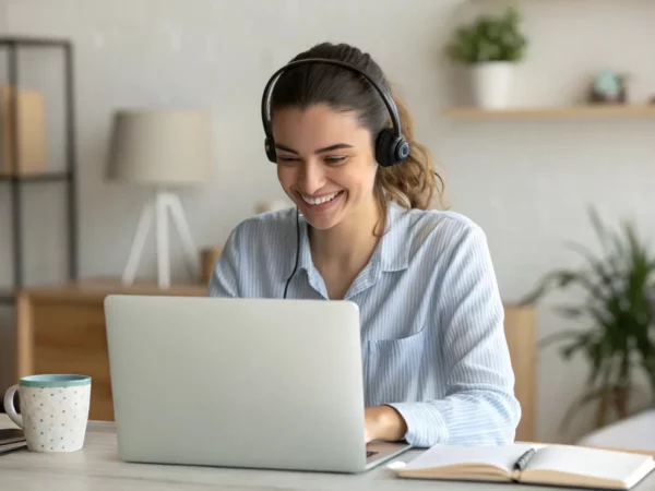 Profissional sorridente trabalhando remotamente em videoconferência, representando engajamento e sucesso no atendimento ao cliente em ambiente home office.